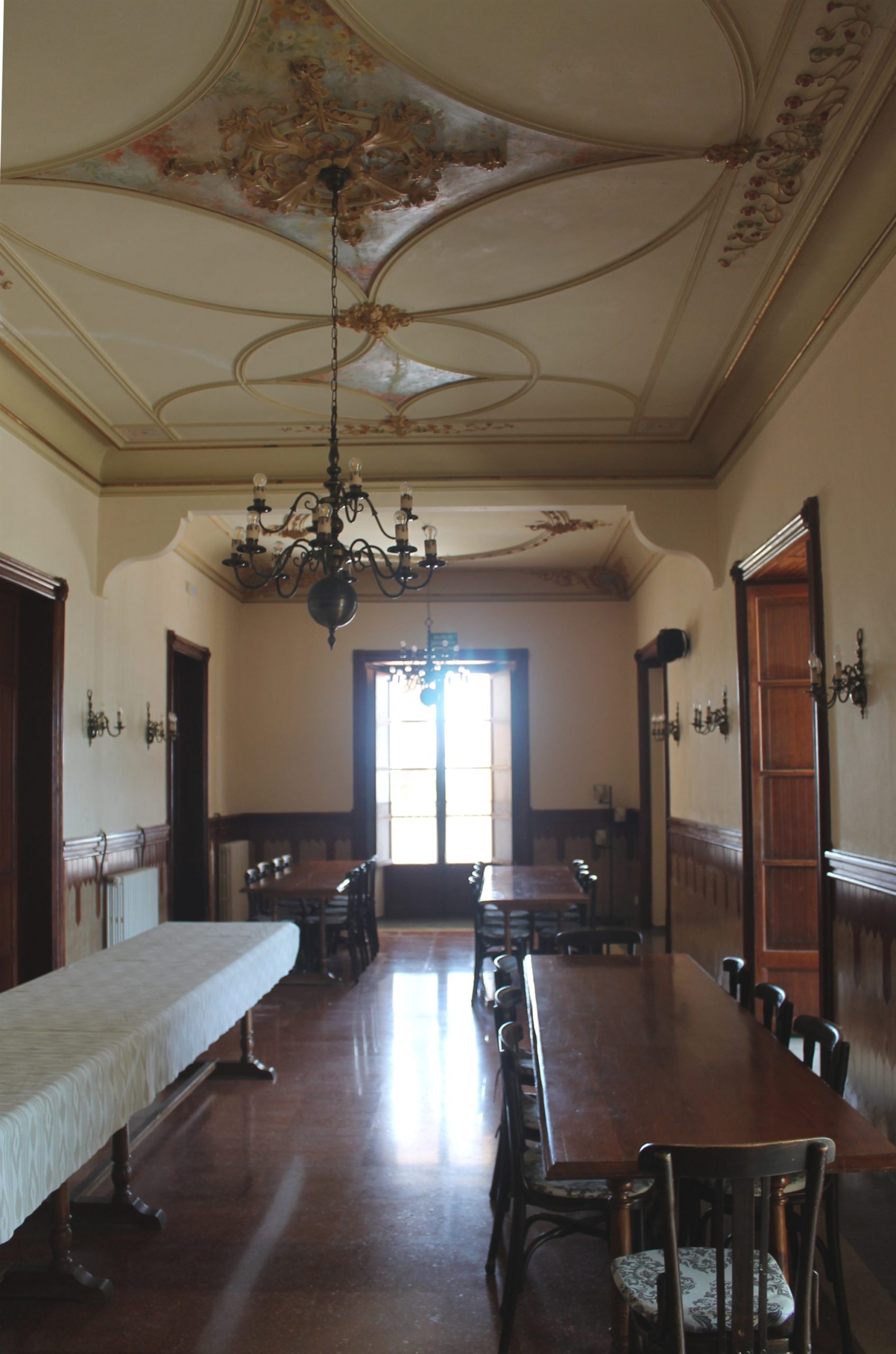 Comedor histórico con techo decorado y lámpara central