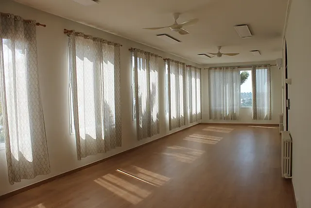 Sala diáfana de Son Bono con grandes ventanales y cortinas